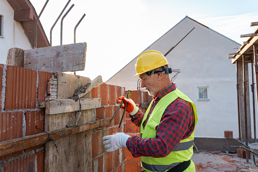 Side-view of a senior Caucasian construction worker, working on a construction site