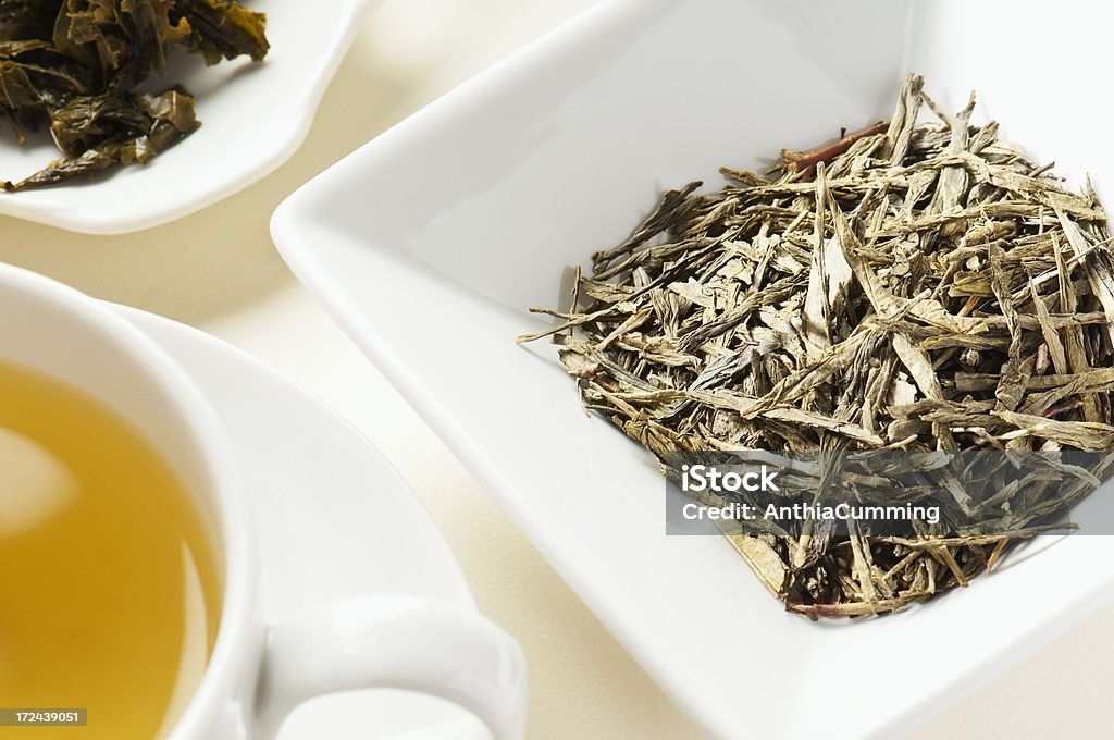 Japanese Bancha green tea leaves behind cup of tea A cup and bowl of Dried Japanese Green Bancha Tea Landscape Chai Stock Photo