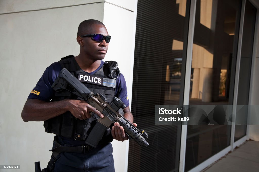 Oficial de policía de retención de rifle - Foto de stock de Afrodescendiente libre de derechos