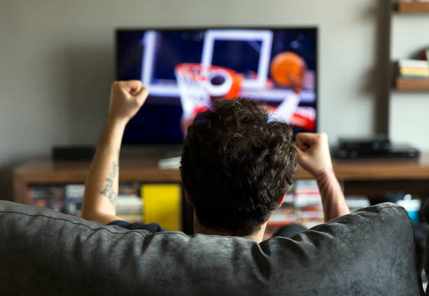 hombre mirando básquetbol en televisión - sport watching television broadcasting television fotografías e imágenes de stock