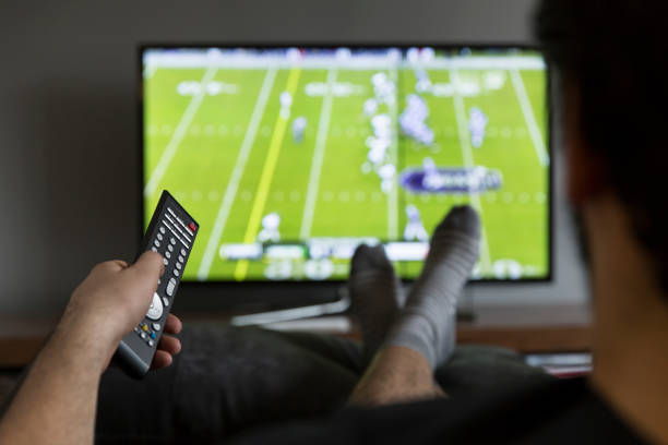 Watching tv man watching American football on tv football socks stock pictures, royalty-free photos & images