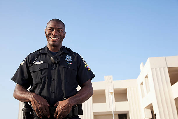 Police officer Young, African American police officer (20s). police force smiling officer stock pictures, royalty-free photos & images