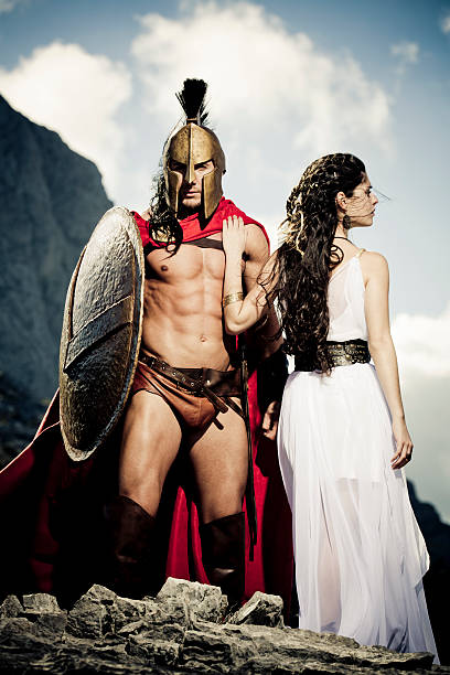 spartan warrior taking leave of his queen spartan warrior taking leave of his spartan queen,selfmade theater clothings and original spartan symbol, adopted in the 420s BC, was the letter lambda (Λ), standing for Laconia or Lacedaemon, which was painted on the Spartans' shields and broochs,selective focus very creative color retouching to underline the ancient time,vignetting, added noise,some areas with overexposing because of the sunlight sparta greece photos stock pictures, royalty-free photos & images