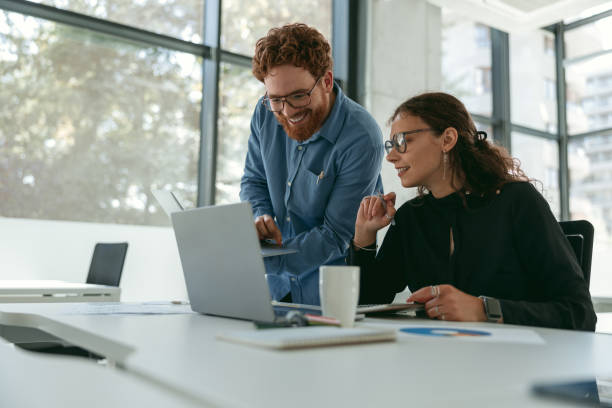 istock Two diverse business colleagues disscuss biz issue while use laptop in office background 1724396953