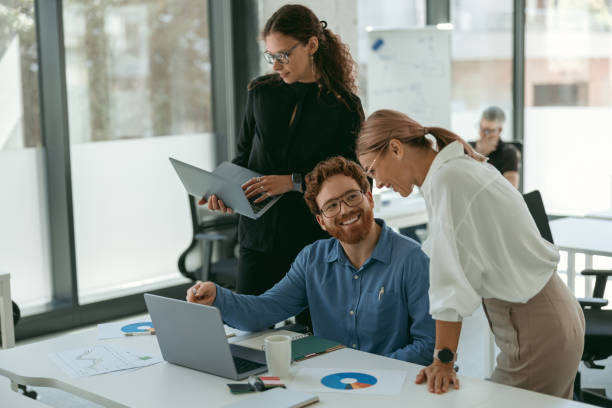 istock Group of business people discussing something and smiling while sitting at the office table 1724398011