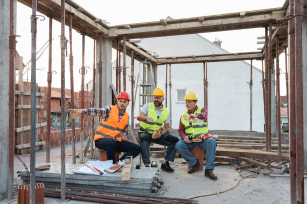 Caucasian architect, building contractor and engineer, talking during an lunch break on a construction site Male Caucasian architect, building contractor and engineer, having an lunch break on a construction site construction lunch break stock pictures, royalty-free photos & images