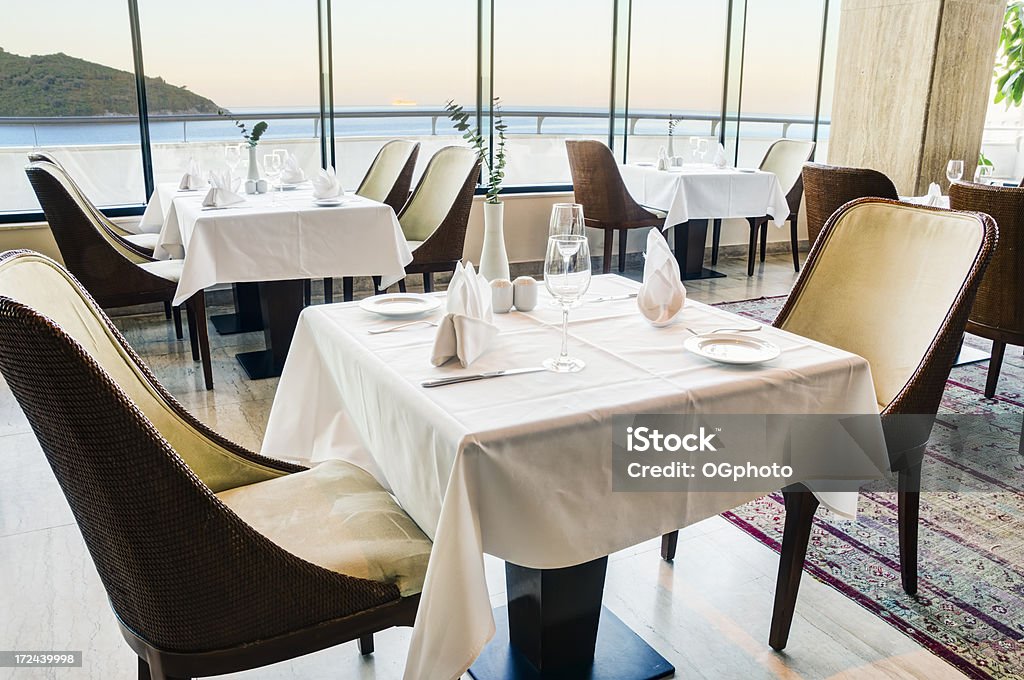Tables at a restaurant with an ocean view Tables at a restaurant with an ocean view.  A cruise ship can be seen at the horizon. Tablecloth Stock Photo