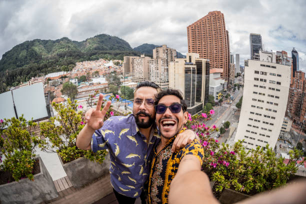 Gay couple taking a selfie at balcony - point of view Gay couple taking a selfie at balcony - point of view personal perspective standing stock pictures, royalty-free photos & images