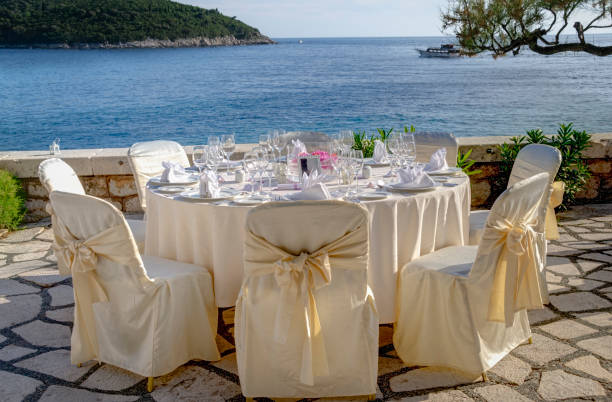 disposición de la mesa para una recepción al aire libre junto al mar - table wedding flower bow fotografías e imágenes de stock