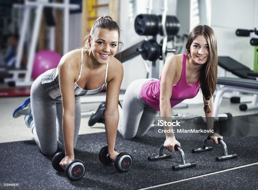 Cute Sporty girls Cute Sporty girls doing exercise in a fitness center. Looking At Camera. 20-24 Years Stock Photo