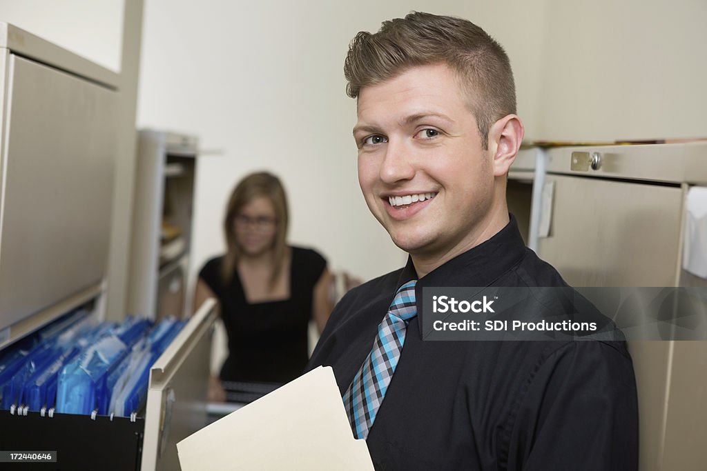 Giovane adulto Uomo d'affari al lavoro in ufficio sala di file - Foto stock royalty-free di Adulto