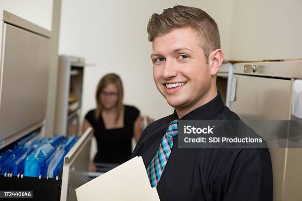 Young Adult Businessman Working In File Room Of Office Stock Photo - Download Image Now