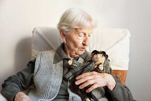 porttrait of a 90 years old woman, with her handmade doll