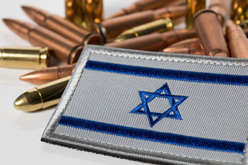 Closeup of Israel flag with rifle ammunition. War between Israel and Lebanon. 7.62x39 ammunition. IDF military. Conflict situation and fighting crisis.