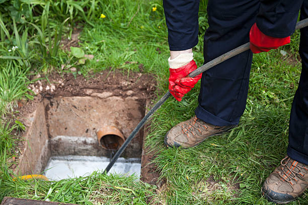 man with ground open unblocking a drain with a tool - avloppsvatten bildbanksfoton och bilder