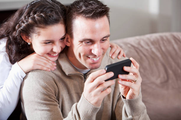 istock Father and daughter looking at mobile device 172441463