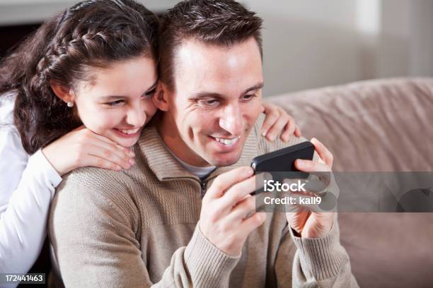 Father And Daughter Looking At Mobile Device Stock Photo - Download Image Now - 10-11 Years, 30-39 Years, Adult