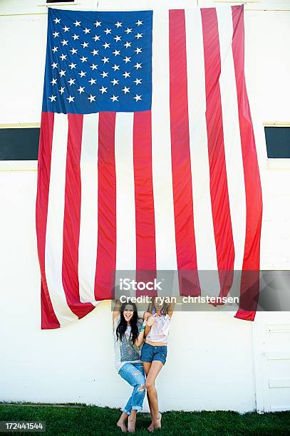 Foto de Bela Jovem Mulher Em Pé Por Uma Bandeira Americana Contra A Parede e mais fotos de stock de Descalço