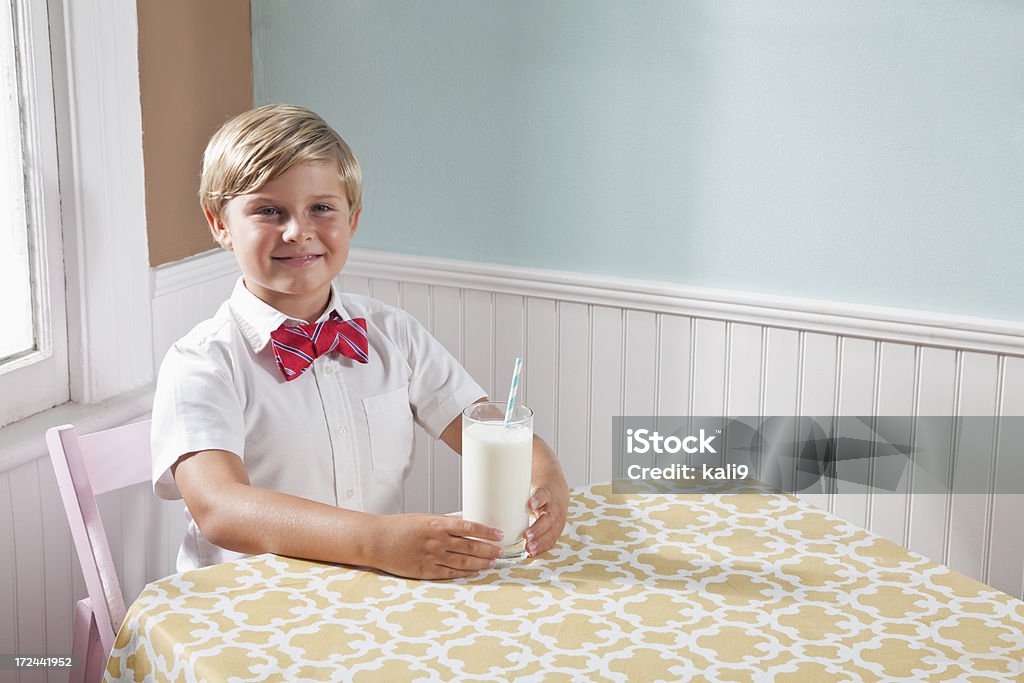Boy drinking glass of milk Boy (8 years) drinking glass of milk with straw. 8-9 Years Stock Photo