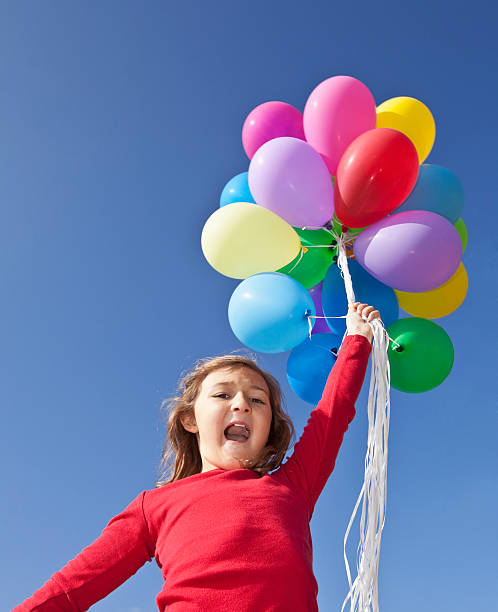 istock Girl holding balloons 172442321