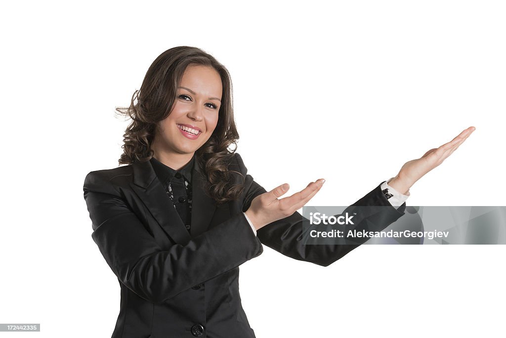 Young Attractive and Confident Businesswoman Showing You Copyspace Over White "Photo of a young attractive and confident businesswoman, smiling and makes a hand gesture. With toothy smile and with both hands showing you copyspace over white background. Dressed in stylish and modern business outfit. Isolated on white background.See more images like this in:" 25-29 Years Stock Photo