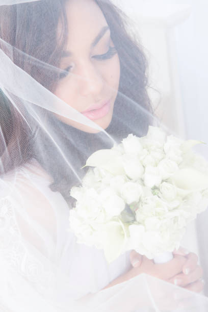 istock Bride holding white bouquet under veil 172442653