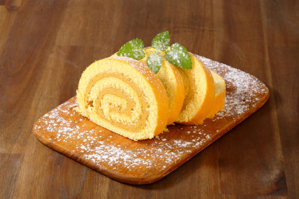 caramel swiss roll slices on a wooden cutting board
