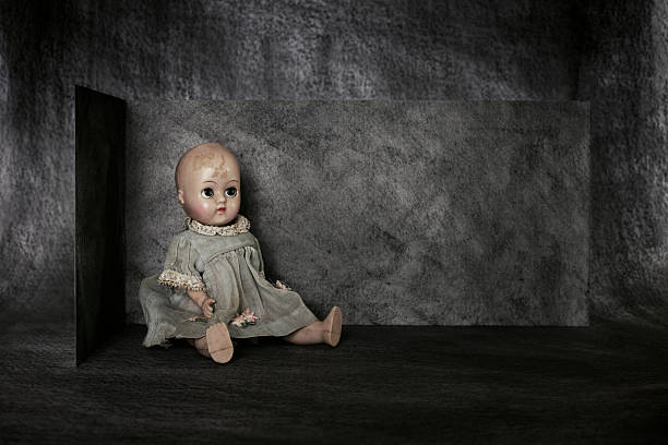 Baby doll A bald headed vintage baby doll sitting against a charcoal painted background. creepy doll stock pictures, royalty-free photos & images