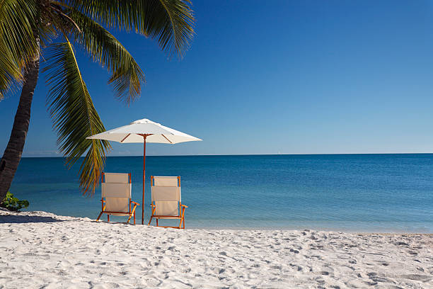 Sombrero beach chairs and umbrella at a tropical beach in the Florida Keys temptation photos stock pictures, royalty-free photos & images