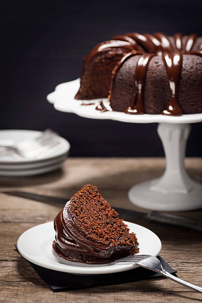 porción de pastel bundt de chocolate ganache cubierto - chocolate bundt cake fotografías e imágenes de stock