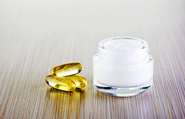 кремовый и витамин таблетки - anti aging pill capsule vitamin pill стоковые фото и изображения
