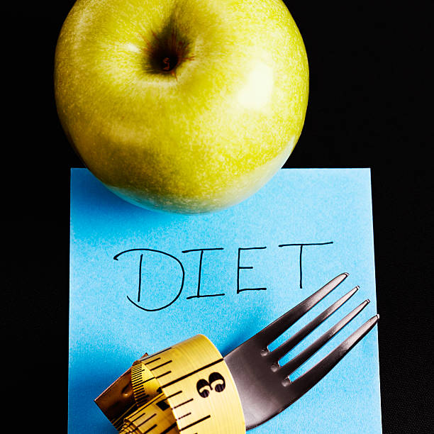 apple, gabel, maßband und ernährung nachricht zu machen! - healthy eating fork tape measure still life stock-fotos und bilder