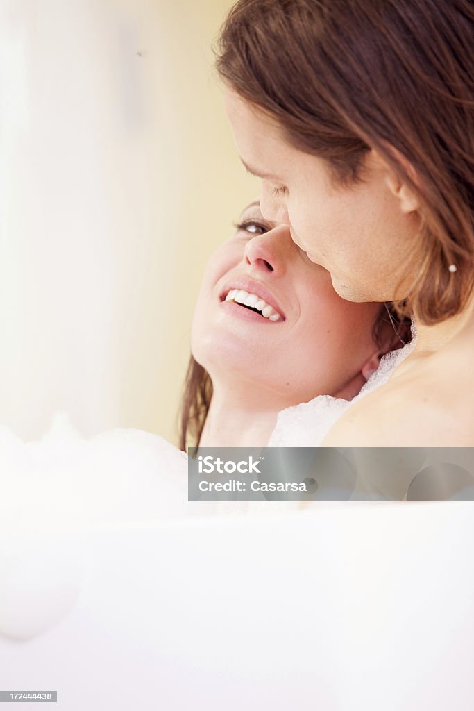 Giovane coppia rilassante nella vasca da bagno - Foto stock royalty-free di Abbracciarsi a letto