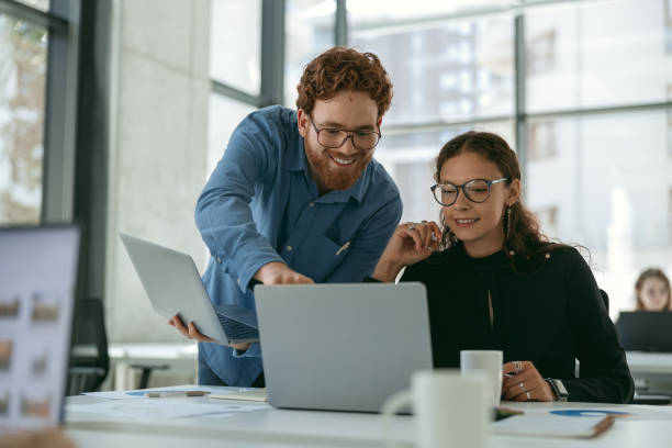 istock Two diverse business colleagues disscuss biz issue while use laptop in office background 1724446148