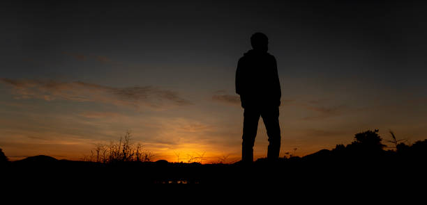 istock Silhouette of a man standing at sunset 1724450486