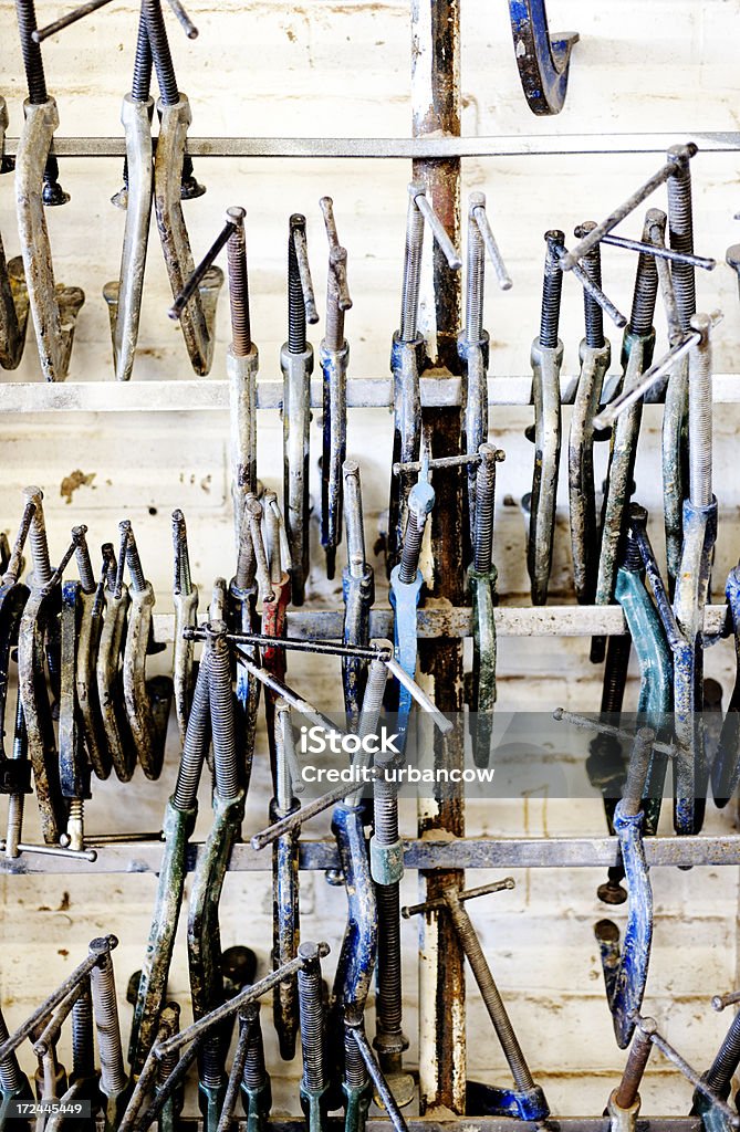 Clamps on rails Metal clamps stored hanging on rails. Boat Building Academy, Lyme Regis  Art And Craft Stock Photo