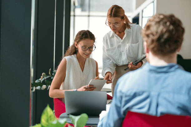 istock Female boss shows something in notebook to employee during working day in office 1724459533