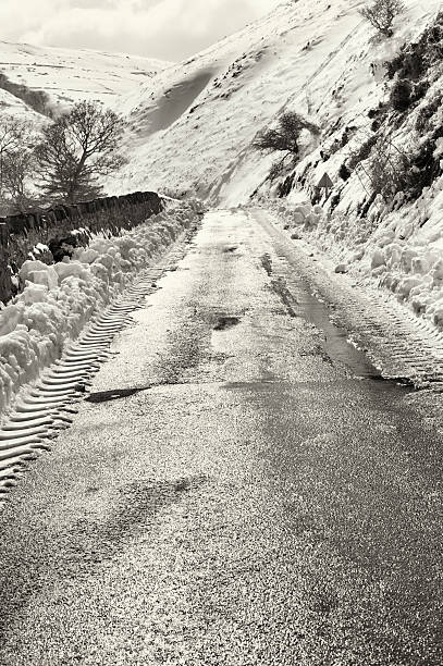 狭い田舎道丘の間に雪の冬の日 - road isweather2012 weather country road ストックフォトと画像