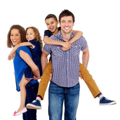 Portrait of couple giving two young children piggyback rides smiling on white background
