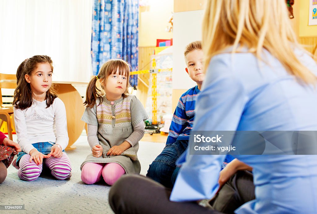 Insegnante parla con i bambini. - Foto stock royalty-free di 25-29 anni