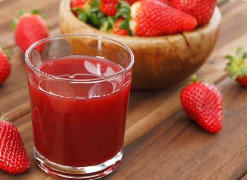 Strawberry juice on wooden background