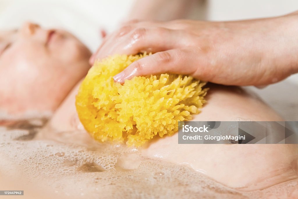 Éponge naturelle, deux mois bébé de bain - Photo de Baignoire pour bébés libre de droits