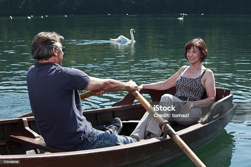 Casal sênior em passeio de barco no lago - Foto de stock de Casal de Meia Idade royalty-free