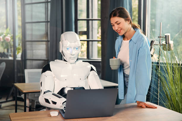 istock Robot and woman working on laptop in office 1724482017