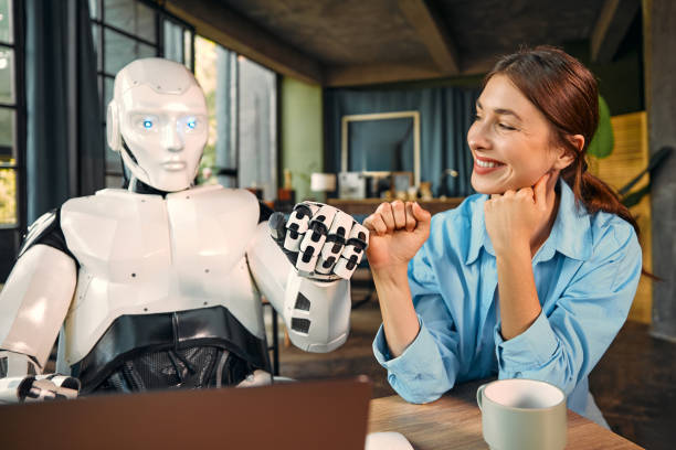 istock Robot and woman working on laptop in office 1724482020