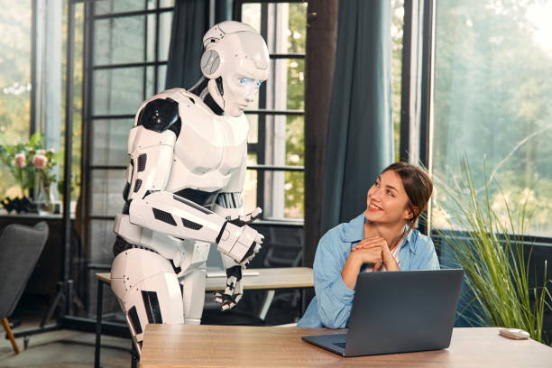 istock Robot and woman working on laptop in office 1724482040