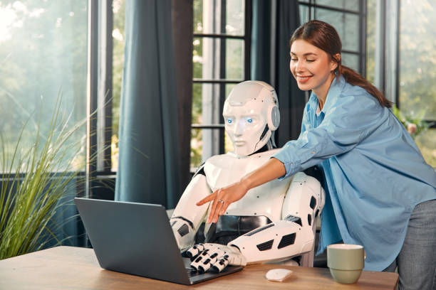 istock Robot and woman working on laptop in office 1724482042