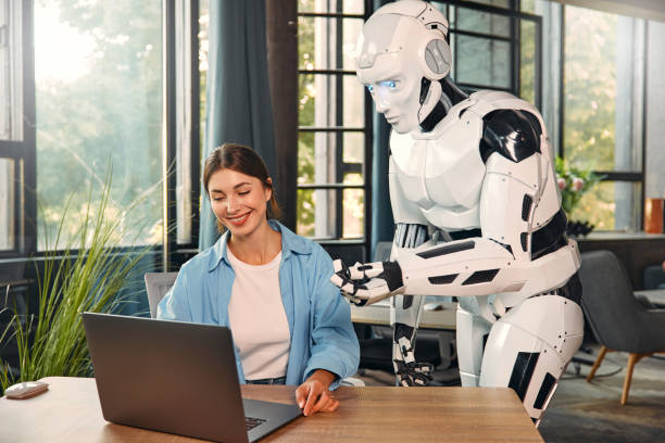 istock Robot and woman working on laptop in office 1724482043