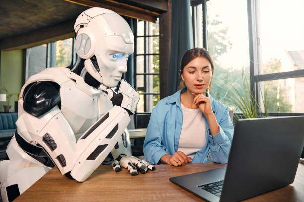 istock Robot and woman working on laptop in office 1724482053