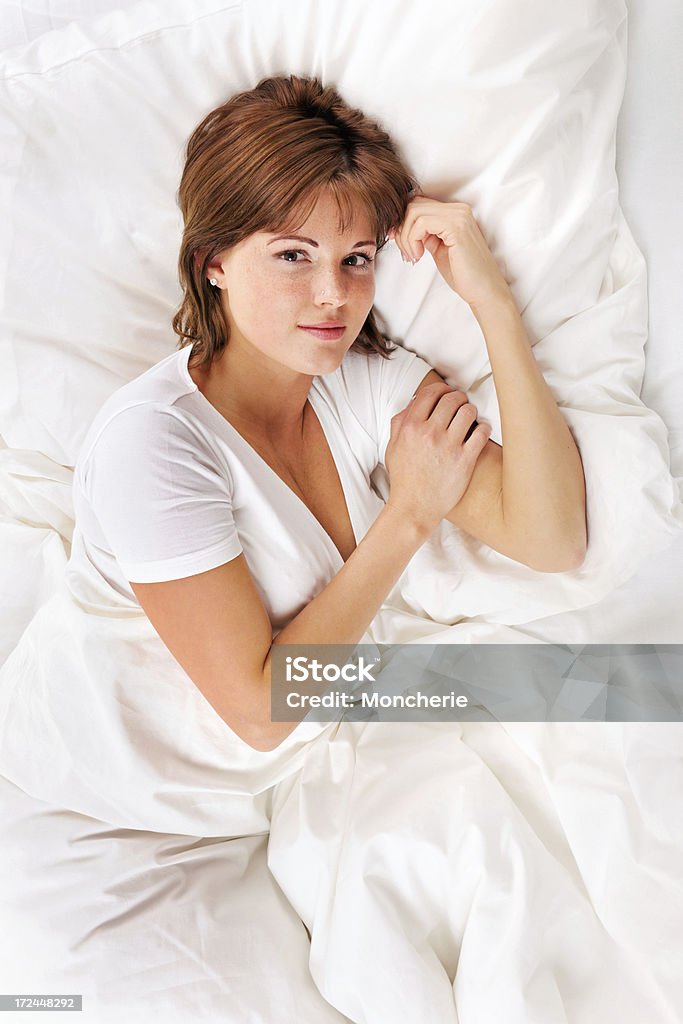 Giovane donna sdraiata a letto - Foto stock royalty-free di Abbracciare una persona